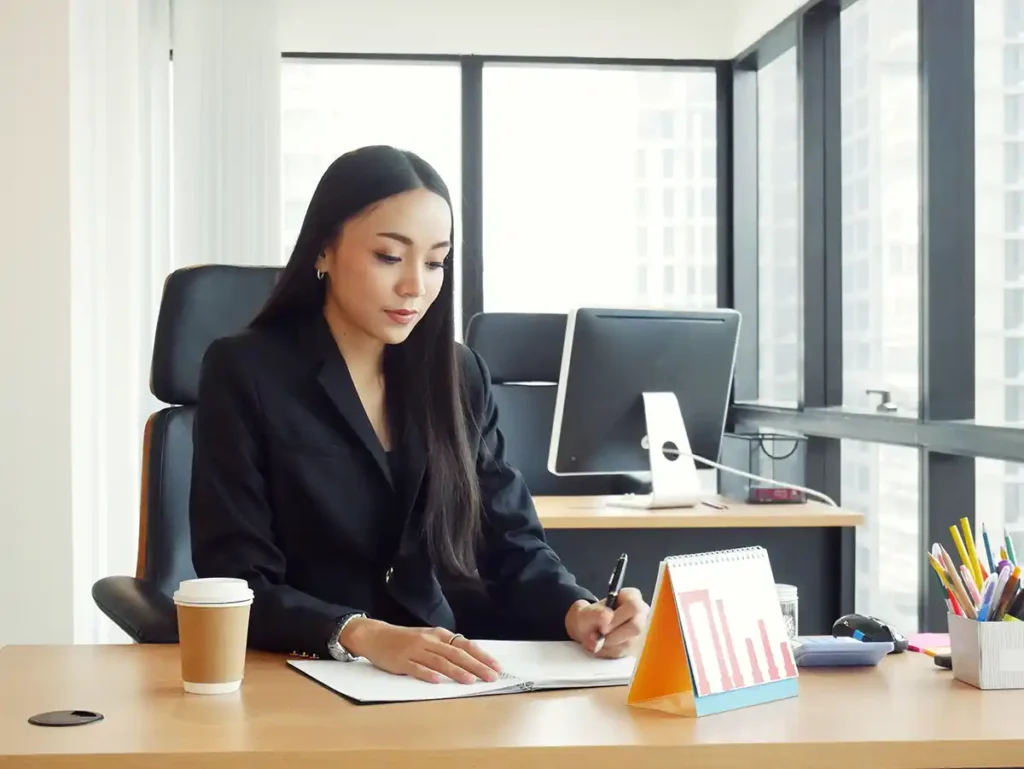 The young secretary is checking the documents on the desk in office.